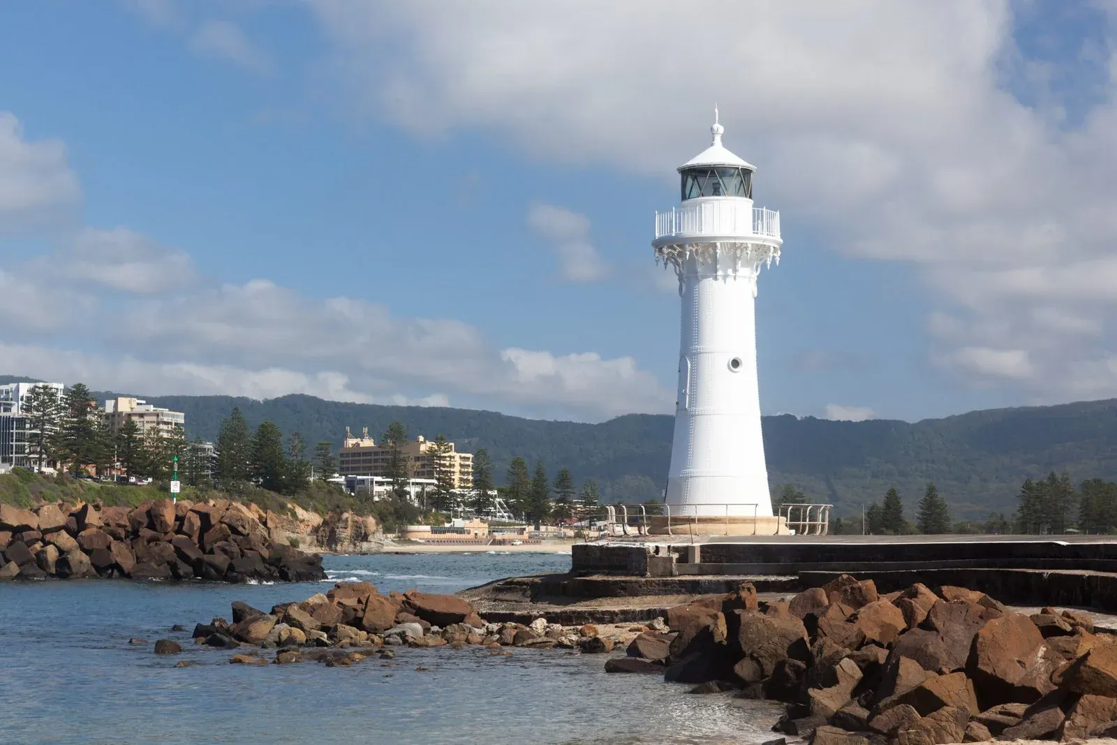 Moving house in Wollongong: the Breakwater Lighthouse at Wollongong Harbour with the escarpment behind