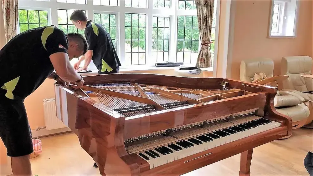 The 777 World Removals crew wrapping a grand piano before moving it